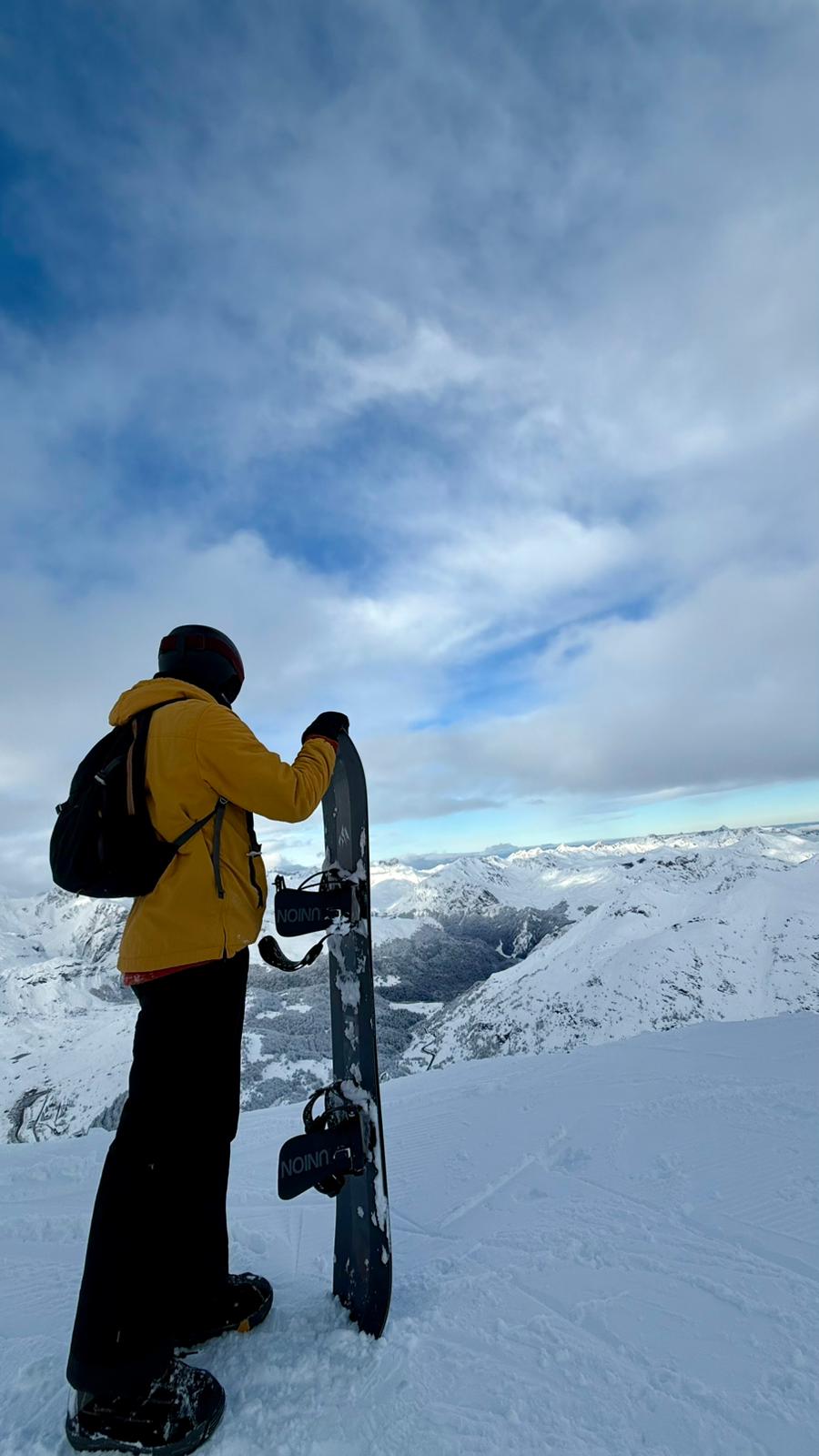 Manu con su tabla de snowboard en la montaña